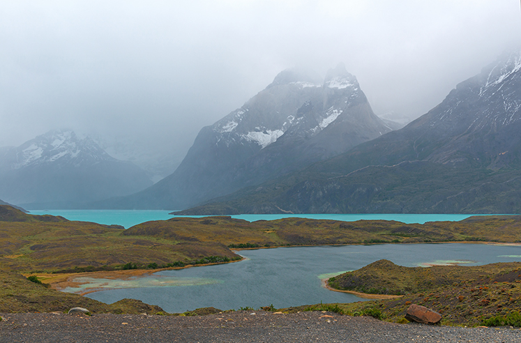 The turquoise colored Nodernskjold lake and the Cuernos del Paine in the fog, located in the Torres del Paine national park near Puerto Natales, Patagonia, Chile.
